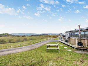 a house with a picnic table in the grass next to a road at 1 Bed in Dalry oc-91418 in Dalry