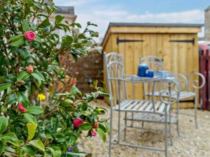 a table and chairs in a garden with a building at 1 Bed in Hawick oc-91437 in Denholm +5 photos