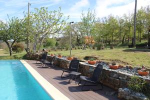 a swimming pool with chairs next to a stone wall at Quinta da Devesa -B2 in Vinhais