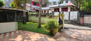 an open gate to a yard with a house at Ritu Heritage Homestay in Trivandrum +2 photos