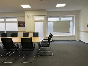 a classroom with tables and chairs and a whiteboard at Hotel Hohenstaufen in Koblenz