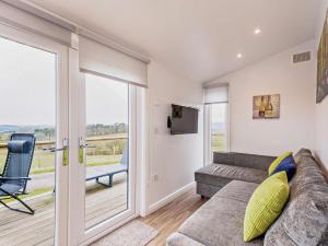 a living room with a couch and a sliding glass door at 1 Bed in Dalry oc-91417 in Dalry