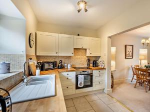 a kitchen with white cabinets and a sink at 3 Bed in Middleham oc-78935 in Middleham +15 photos
