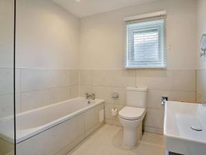a bathroom with a tub and a toilet and a sink at 3 Bed in Swansea oc-91720 in Killay