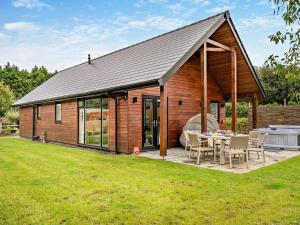 a wooden house with a patio and a grill at 3 Bed in Swansea oc-91720 in Killay