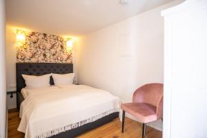 a bedroom with a bed and a chair at Ferienhaus "Zum Lochstein" in Sankt Andreasberg