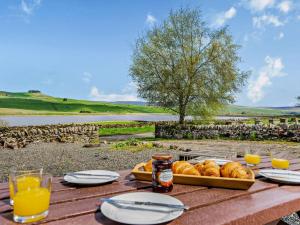 a table with a tray of bread and glasses of orange juice at 2 Bed in Barnard Castle oc-90498 in Middleton in Teesdale