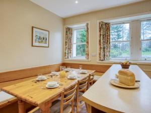 a dining room with a table and chairs and windows at 6 Bed in Fort William oc-ca139 in Fassfern