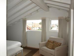 um quarto com uma cama, uma cadeira e uma janela em Posada La Panaderia De Castañeda em Villabáñez