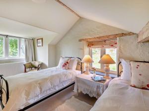a bedroom with two beds and a table with two lamps at 4 Bed in Kendal oc-sz535 in Kentmere