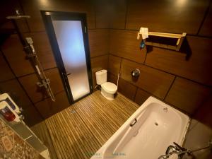 a small bathroom with a tub and a toilet at Lembah Indah Malang in Gendogo