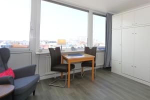 a room with a table and chairs and a window at Rüter 57 w in Westerland