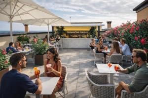 a group of people sitting at tables on a patio at Grand Hotel San Lorenzo in Mantova
