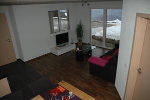 uma sala de estar com um sofá e uma televisão em Panoramachalet em Agettes