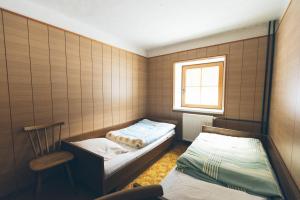 a small bedroom with two beds and a chair at Tamar Mountain hut in Rateče