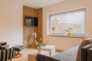 a living room with a couch and a window at Lago Edera - Talblick in Hemfurth-Edersee