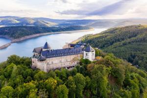 an aerial view of a castle on a hill next to a lake at Lago Edera - Seeblick in Hemfurth-Edersee