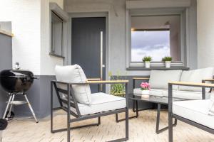 a patio with two chairs and a grill at Lago Edera - Talblick in Hemfurth-Edersee