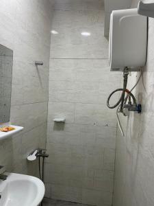 a bathroom with a shower with a sink and a toilet at DAVAROXE Appartements Lingwala RTNC in Kinshasa