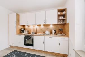 a white kitchen with white cabinets and appliances at Wolfswarte in Braunlage
