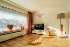 a living room with a large window and wooden floors at Wolfswarte in Braunlage