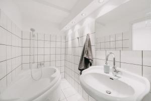 a white bathroom with a tub and a sink at Wolfswarte in Braunlage +11 photos