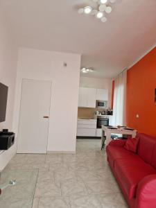 a living room with a red couch and a kitchen at Palazzo interno 3 in Giovinazzo