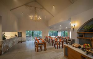 a dining room with tables and chairs and a chandelier at Blanket Riverside Resort and Spa in Munnar