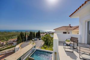 ein Balkon mit Swimmingpool und Blick auf eine Straße in der Unterkunft SUNLIGHT Spain in Manilva