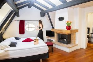 a woman standing in a bedroom with a fireplace at Tralala Hotel Montreux in Montreux
