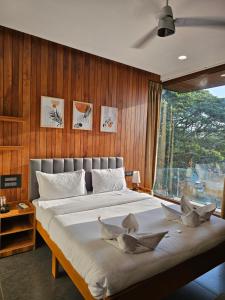 a bedroom with a large bed with wooden walls at Hotel Navas Inn- Pure Veg, Kolhapur in Kolhapur +178 photos