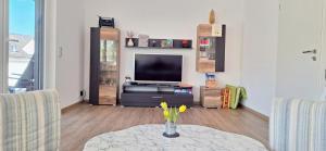 a living room with a table and a tv at Ferienwohnung Wagner in Neumagen-Dhron