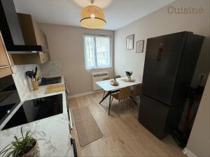 a kitchen with a small table and a black refrigerator at Appartement paisible in Limoges