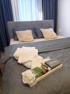 a tray with towels and a book on a bed at Apartment Aby - Free Parking & Self Check-in in Slavonski Brod