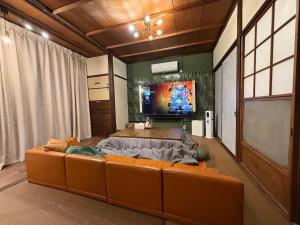 a living room with a couch and a flat screen tv at 一棟貸し宿 maicca2 in Numazu