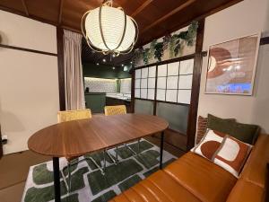 a dining room with a table and a couch at 一棟貸し宿 maicca2 in Numazu