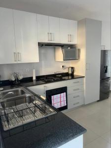 a kitchen with a sink and a stove top oven at Naledi Inn in Gaborone