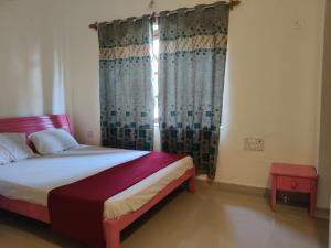 a bedroom with a bed and a window with curtains at The Coastal Villa Arpora in Parra +18 photos