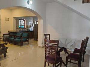 a dining room and living room with a table and chairs at The Coastal Villa Arpora in Parra