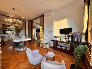 a living room with white chairs and a piano at Hotel La Fontana in Stresa