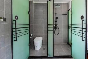 a bathroom with a toilet and a shower with glass doors at Bor Manju Vacation guesthouse--Near the Ticket Gate--service in Chinese and English in Zhangjiajie +49 photos