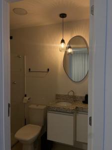a bathroom with a toilet and a sink and a mirror at Vila confort in Vila Velha +13 photos