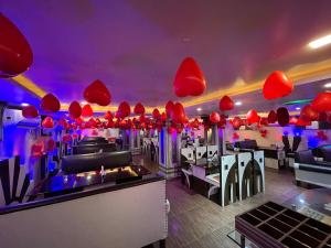 a restaurant with red umbrellas hanging from the ceiling at Hotel Kep's - A Business Class Hotel in Contai