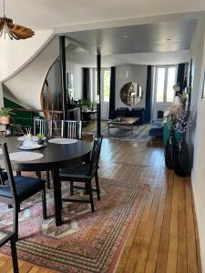 a dining room and living room with a table and chairs at Duplex de charme en centre ville avec terrasse in Brive-la-Gaillarde