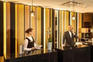 a man and a woman standing at a desk in an office at Best Western Plus Delta Park Hotel in Mannheim