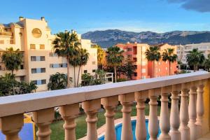 a balcony with a view of buildings and palm trees at Attic Duplex Apartment with 4 terraces & 5 min walk to Beach in Denia