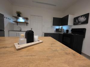 a kitchen with a table with a bottle of soap on it at The041Stay in Gqeberha