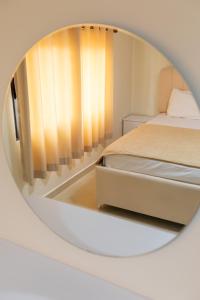 a mirror reflecting a bedroom with a bed at Vila Emi Apartment's in Durrës