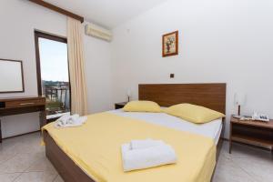 een slaapkamer met een groot bed met gele lakens en gele kussens bij Villa Katarina in Trogir