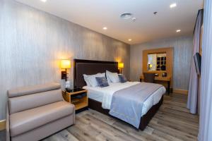 a hotel room with a bed and a chair at Hotel Golden Palace in Shkodër +75 photos